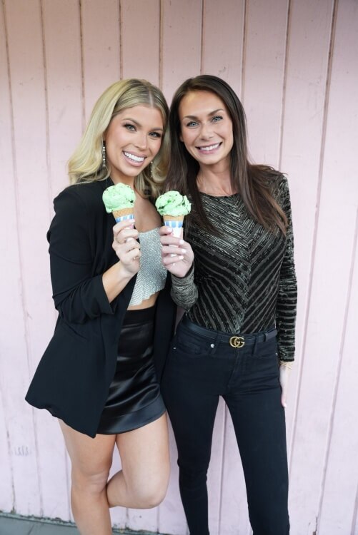 Dr. Bri and another woman hold ice cream cones against a pink wall in Scottsdale, AZ