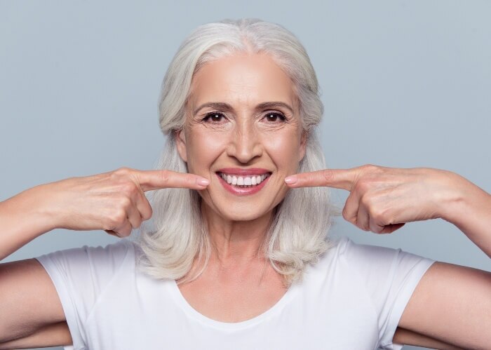 A woman showing the after results of her dental implants in Scottsdale, AZ.