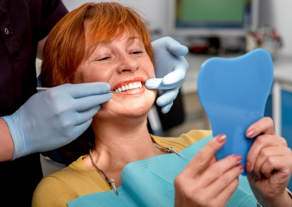 Older Female Checking her Partial dentures at S&C Dental