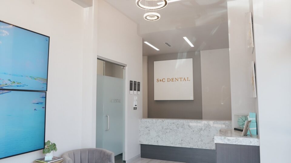 The front desk at S&C Dental Scottsdale, with the gold S&C Dental sign above a marble counter